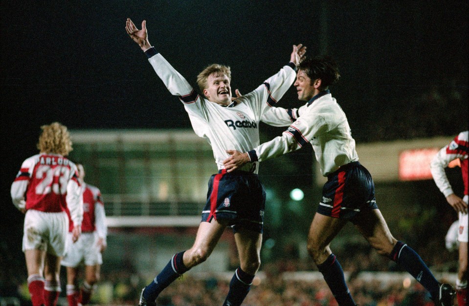 two soccer players wearing reebok jerseys are jumping in the air