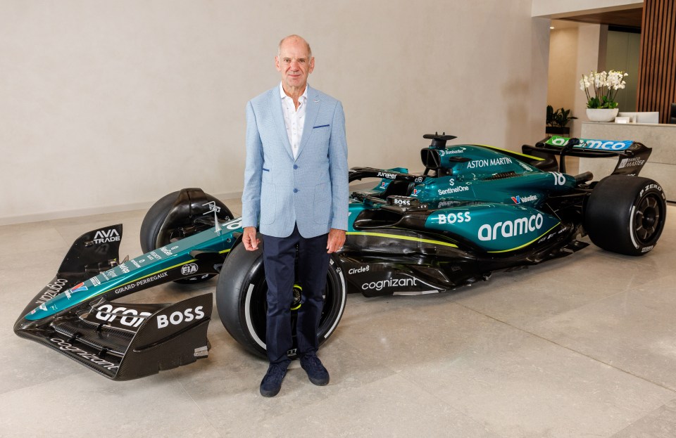 a man stands in front of a green and black aramco race car