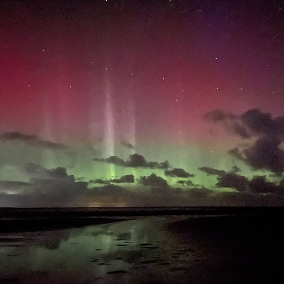 the aurora borealis shines brightly in the night sky over the ocean