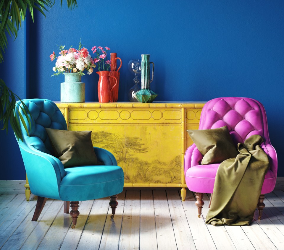 two colorful chairs sit in front of a blue wall