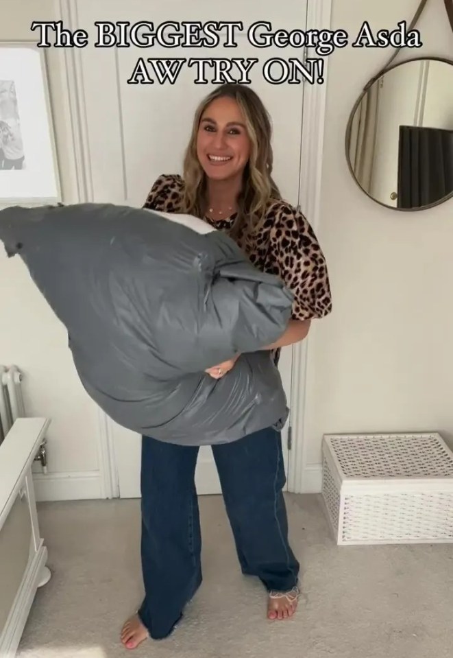 a woman is holding a large gray pillow with the caption " the biggest george asda aw try on "