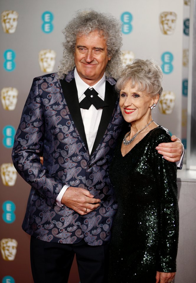 a man and woman are posing for a picture on a red carpet