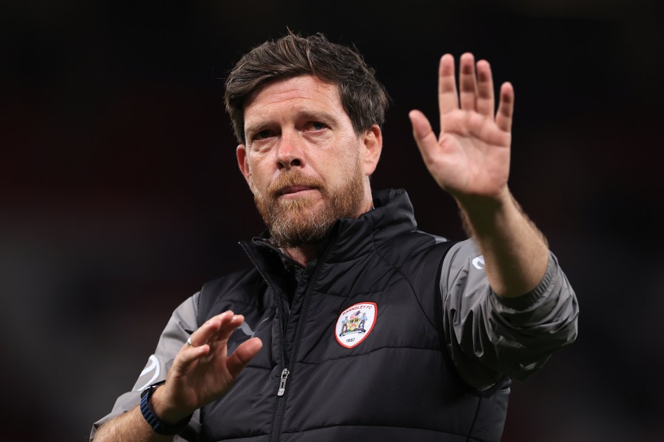 a man with a beard wears a jacket that says manchester united