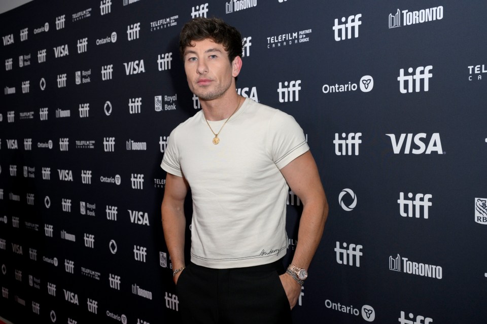 a man stands in front of a wall that says tiff on it