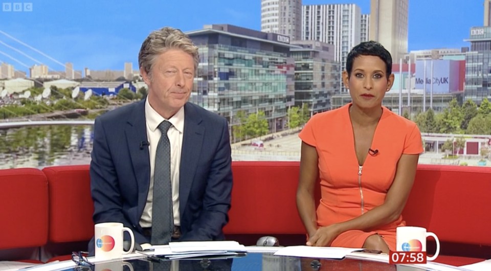 a man in a suit and tie sits next to a woman in an orange dress