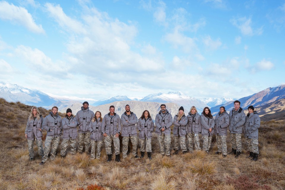 a group of people standing in a field with mountains in the background