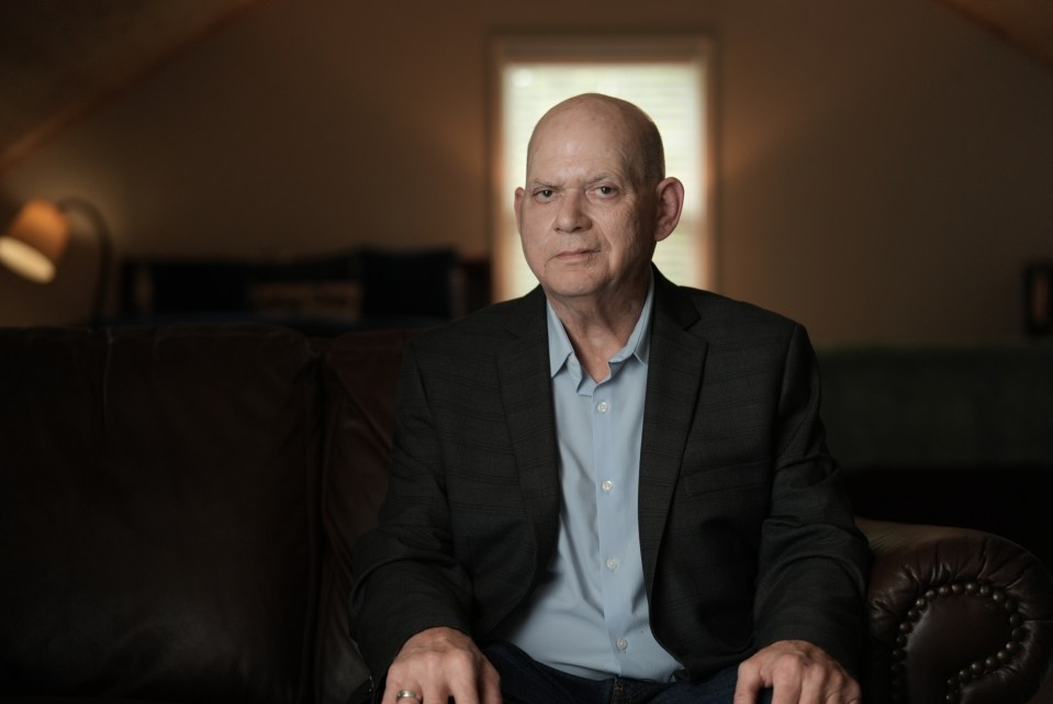 a man in a suit and blue shirt is sitting on a couch