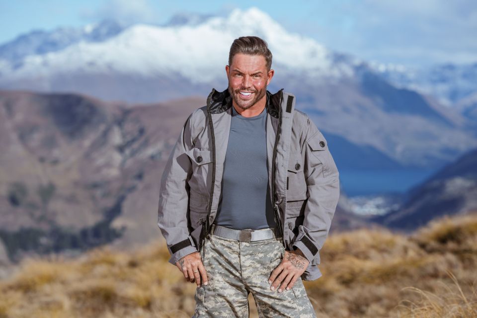 a man in a military uniform stands in front of mountains