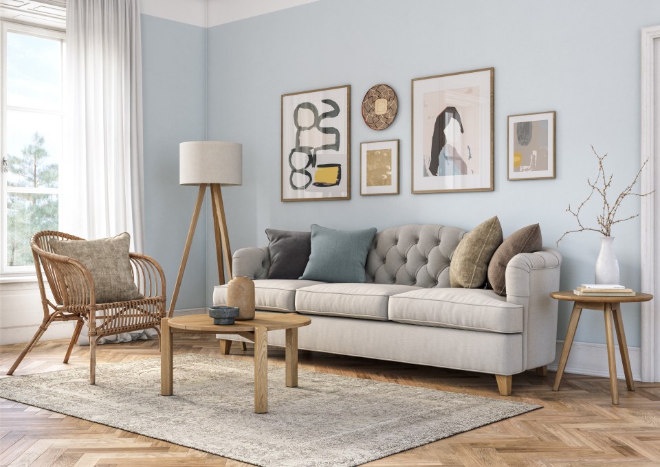 a living room with a couch and a wicker chair