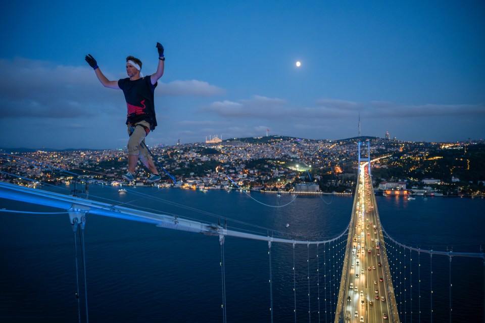 a man is standing on a bridge over a body of water