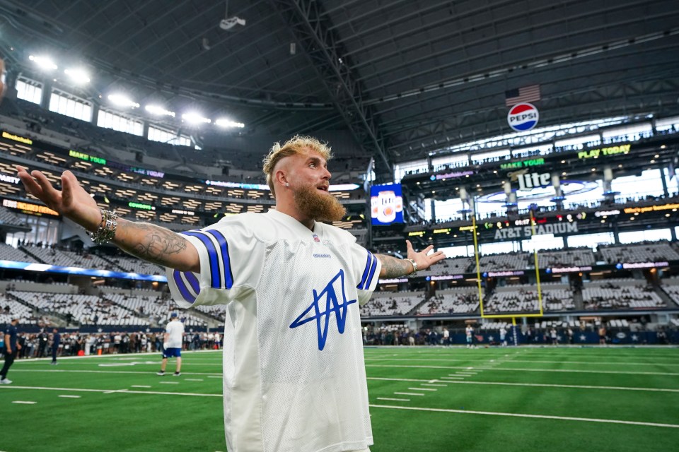 a man stands on a football field in front of a pepsi sign