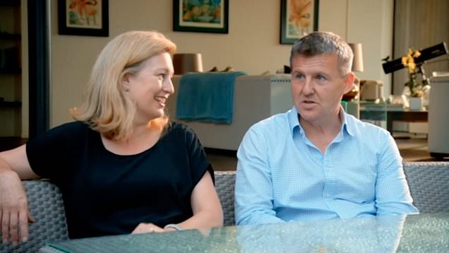 a man and a woman are sitting at a table talking to each other .