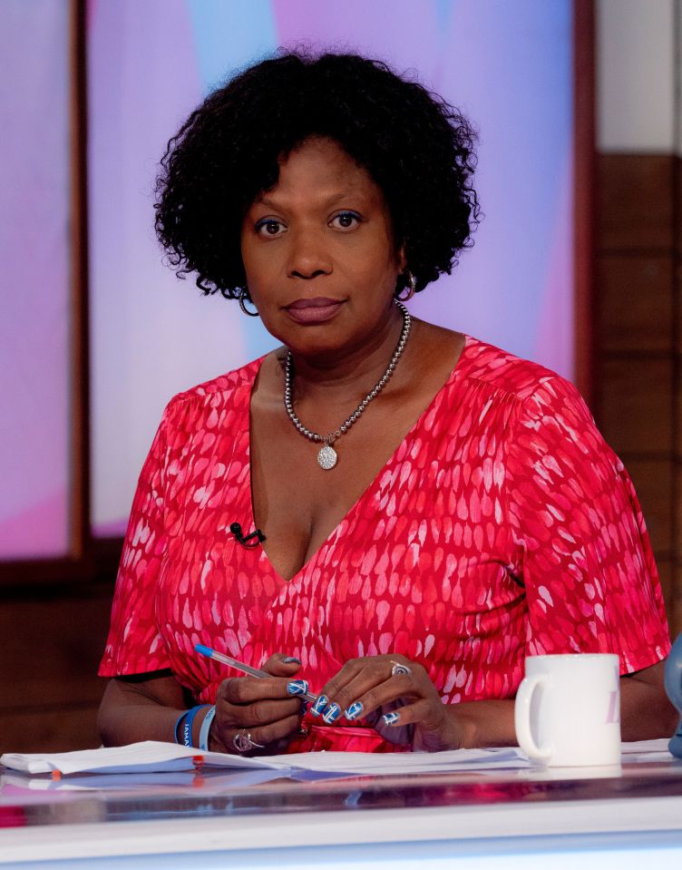 a woman in a pink shirt sits at a desk