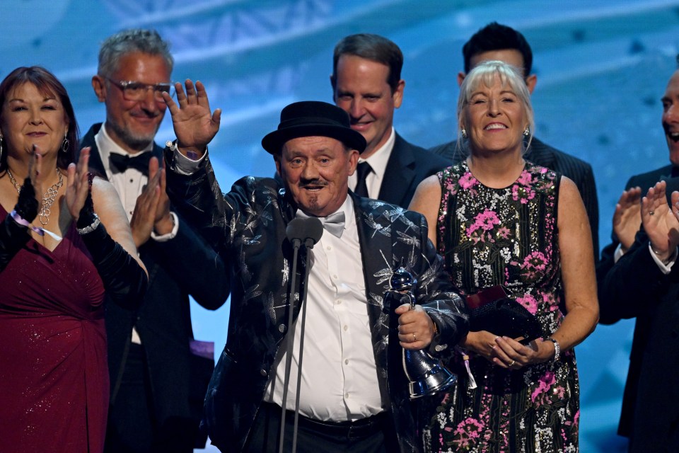 a man and woman are posing for a picture at the national television awards