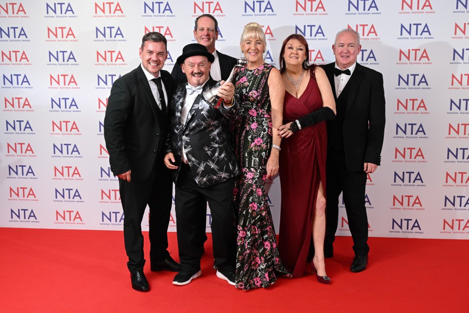 a group of people standing in front of a wall that says nta