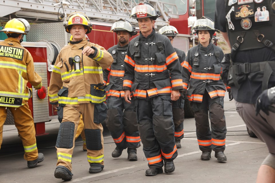 a group of firefighters are walking in front of an austin fire department truck