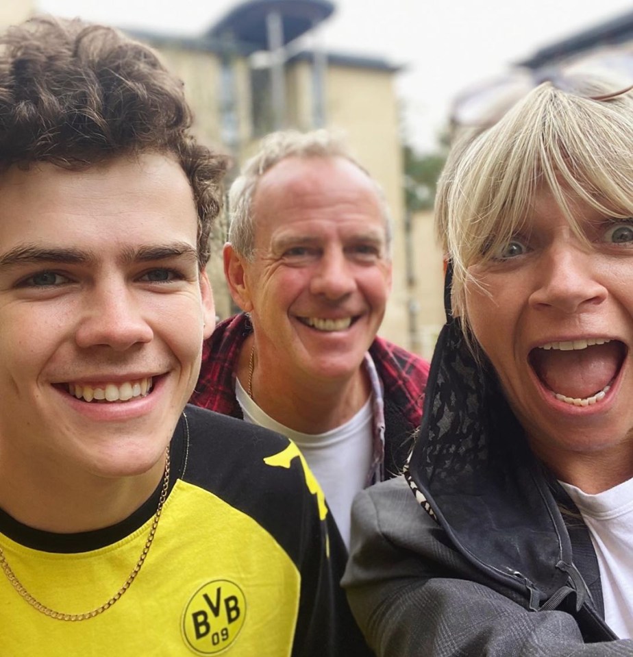 a boy wearing a yellow bvb shirt smiles with his family