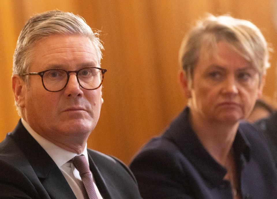 a man wearing glasses sits next to a woman