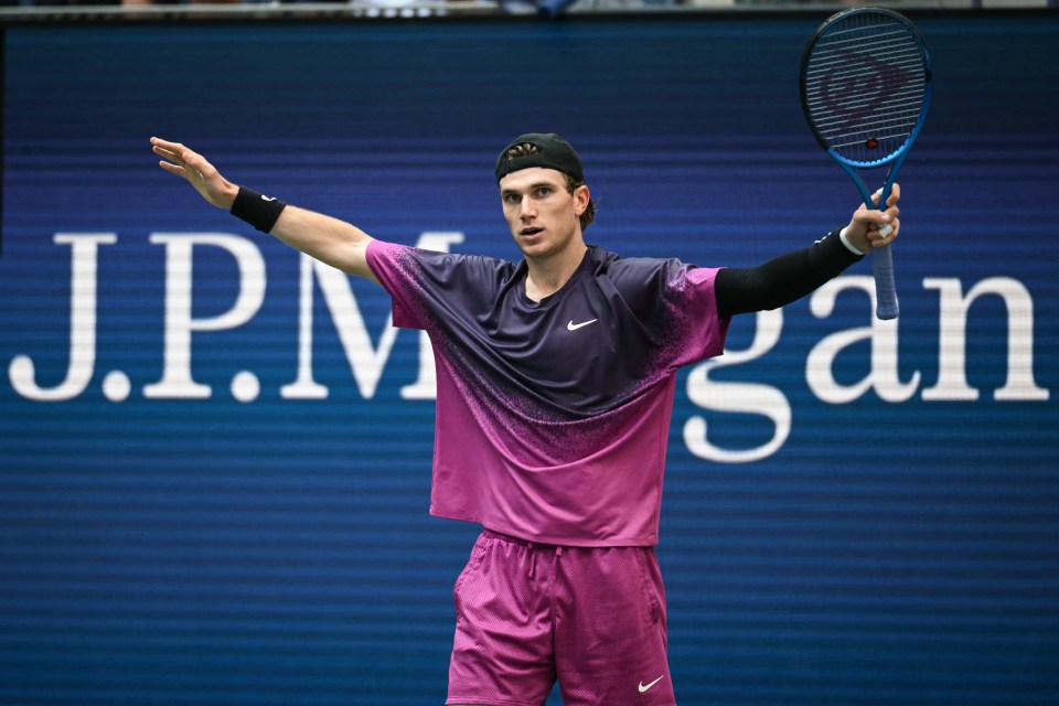 a man holding a tennis racquet in front of a j.p. morgan sign