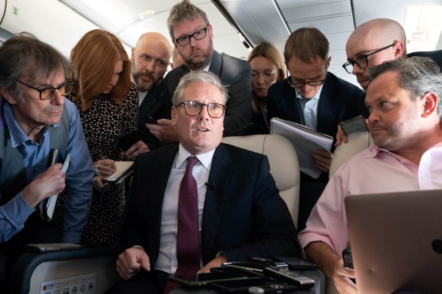 a group of people are gathered around a man in a suit and tie