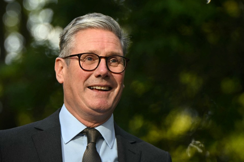 a man wearing glasses and a suit is smiling