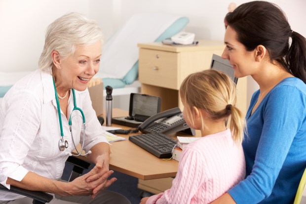 a doctor is talking to a woman and a little girl