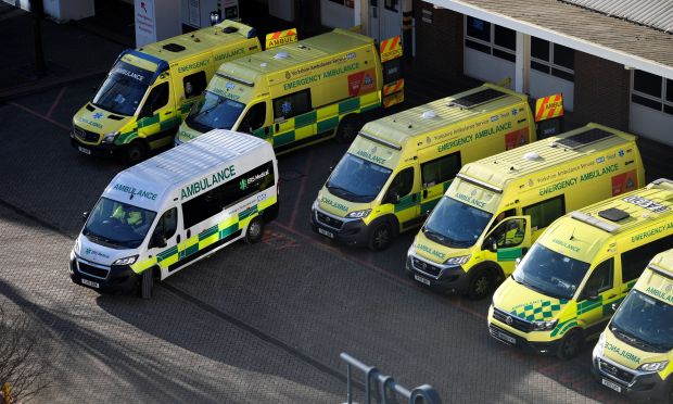 a row of ambulance vans are parked in front of a building