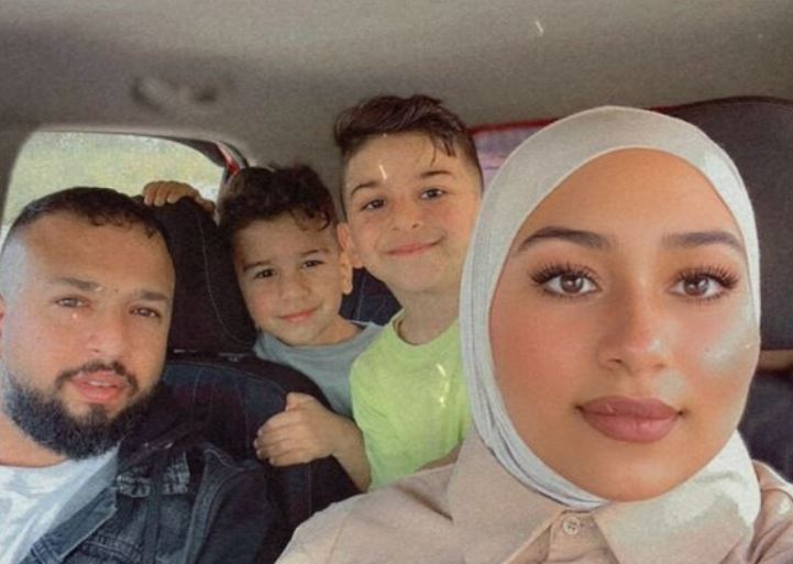 a family is posing for a picture in the back seat of a car .