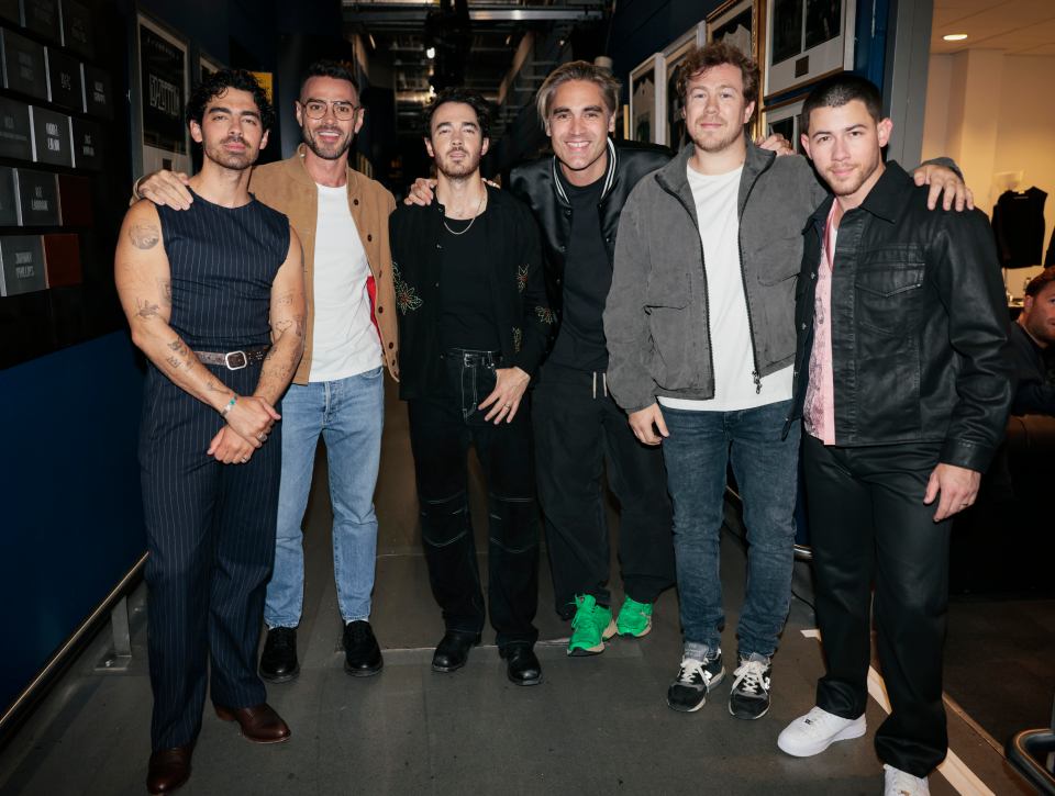 a group of men posing for a picture with one wearing green shoes