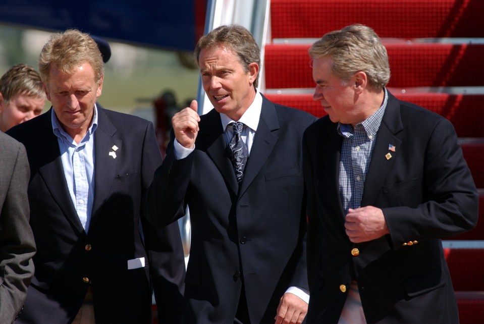 three men in suits are walking on a red carpet