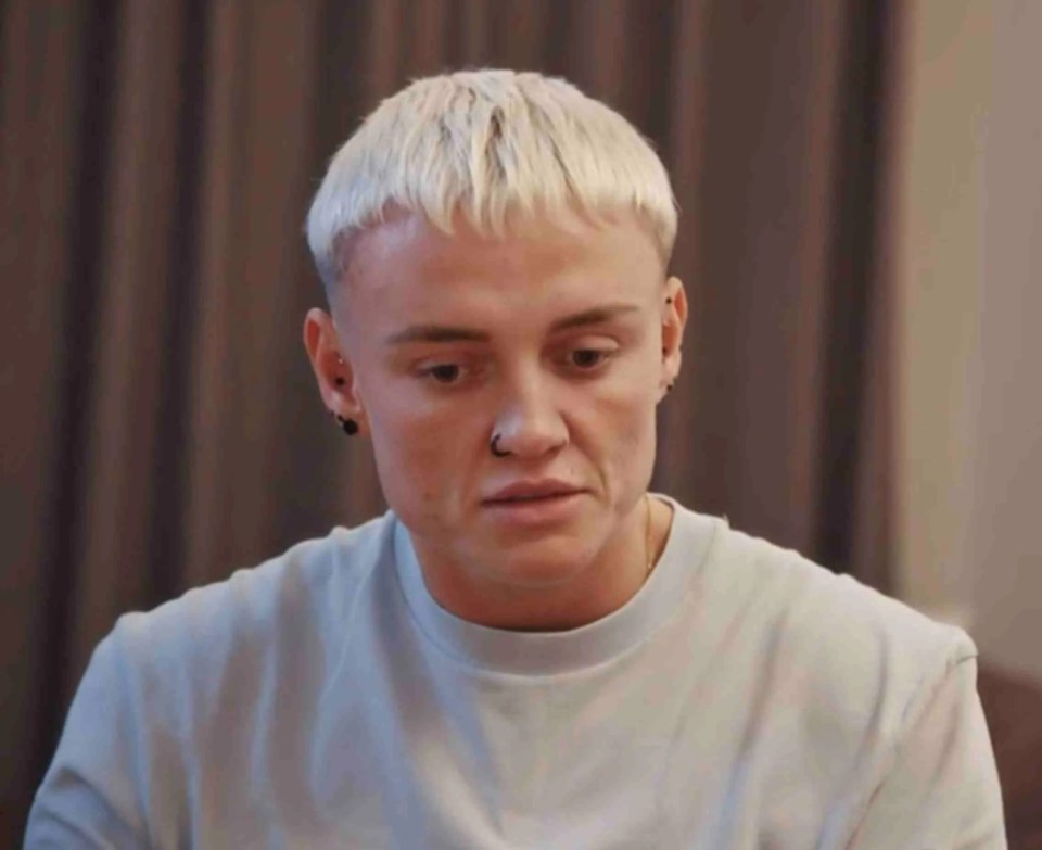 a man with blonde hair is sitting on a couch