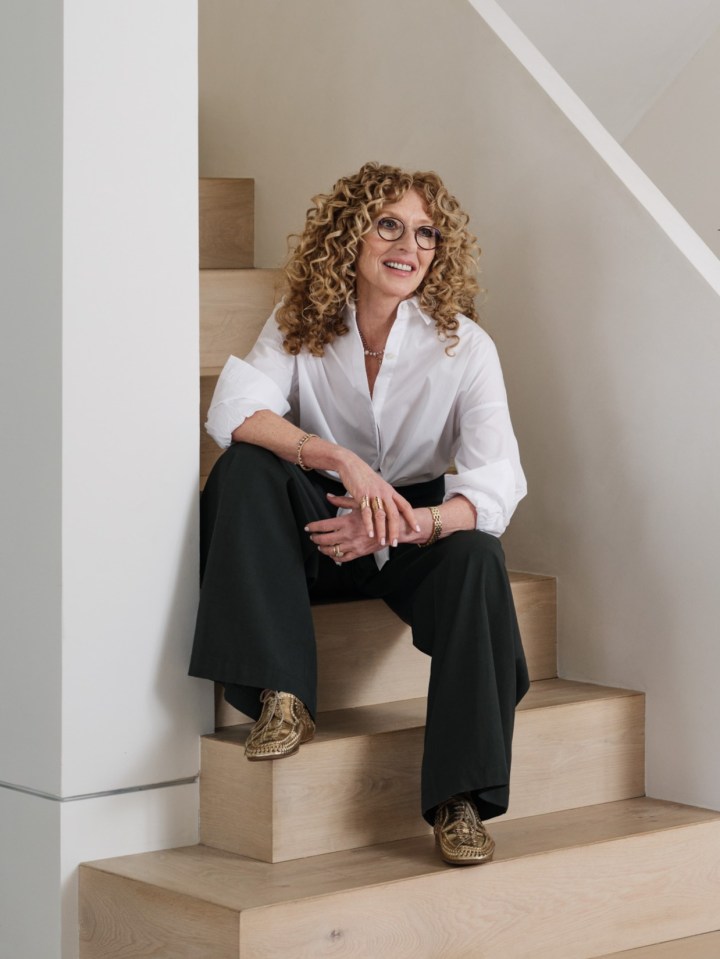 a woman sits on a set of wooden stairs