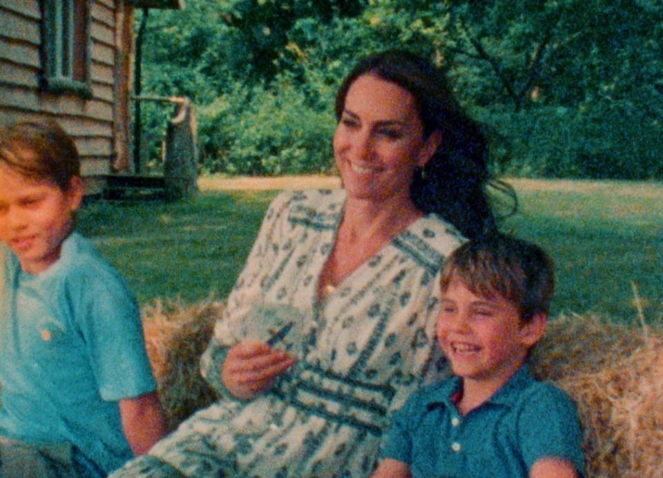 a woman sits on a bale of hay with two children