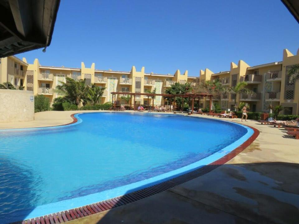 a large swimming pool in front of a hotel