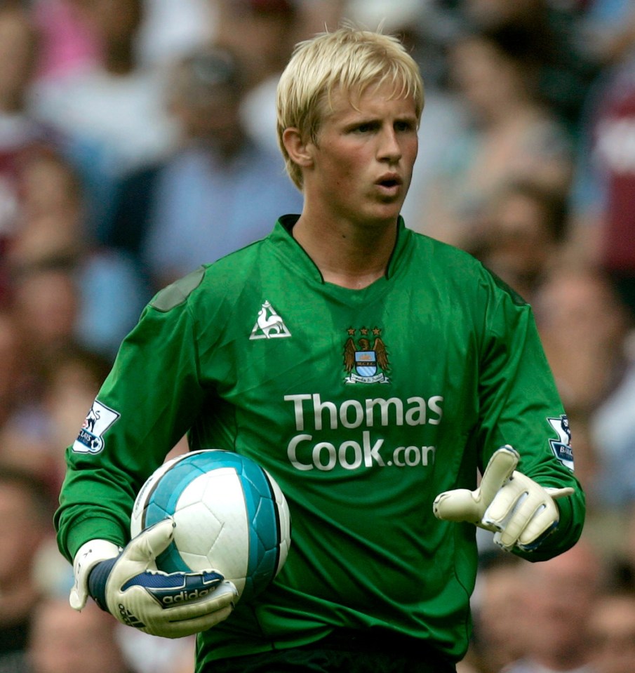 a man in a green thomas cook jersey holds a soccer ball