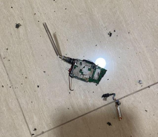 a broken electronic device is laying on a tiled floor