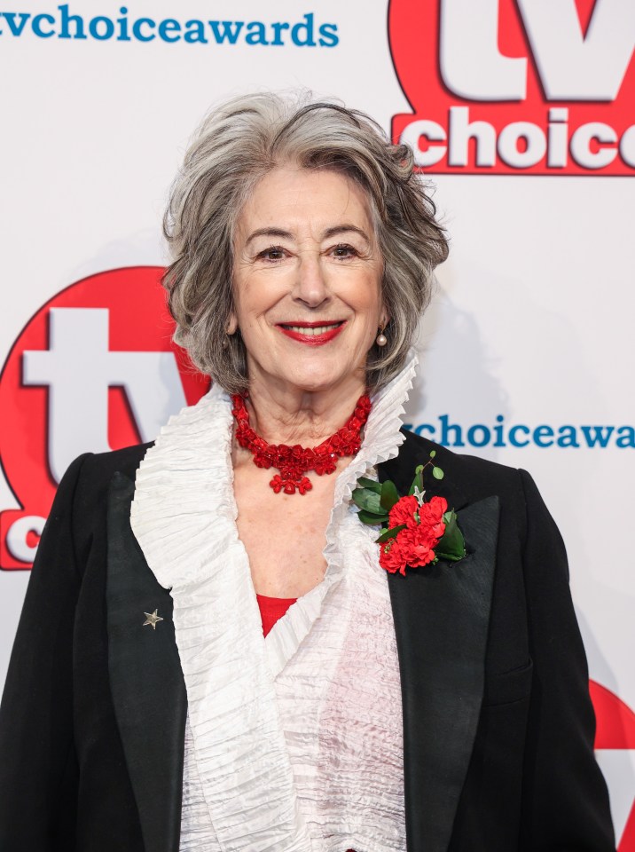 a woman wearing a red necklace and a black jacket stands in front of a tv choice awards sign