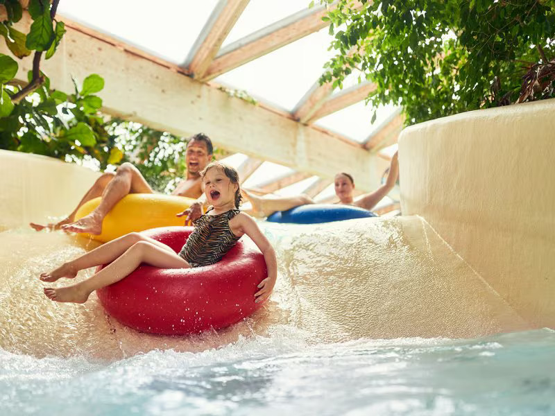 a family is riding down a water slide on tubes