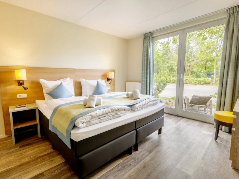 a hotel room with two beds and a large window