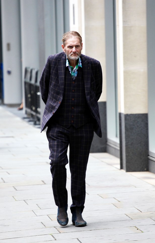 a man in a suit is walking down a sidewalk