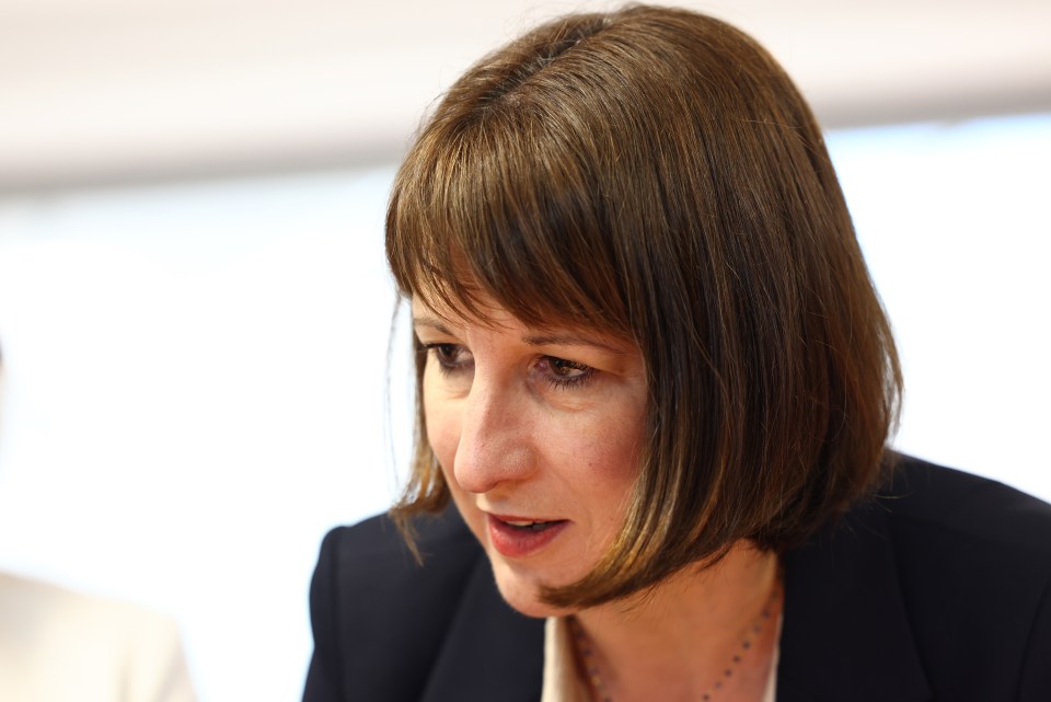 a woman with short brown hair is wearing a black jacket