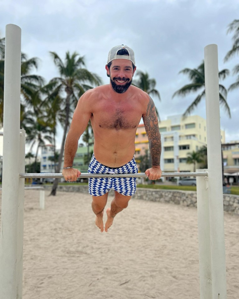 a shirtless man is doing exercises on a bar