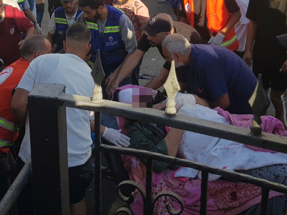 Medics carry a man who was wounded after his handheld pager exploded in the southern port city of Sidon