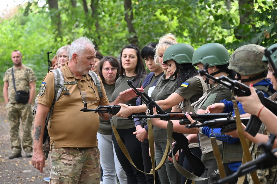 a man with a tattoo on his arm is talking to a group of soldiers