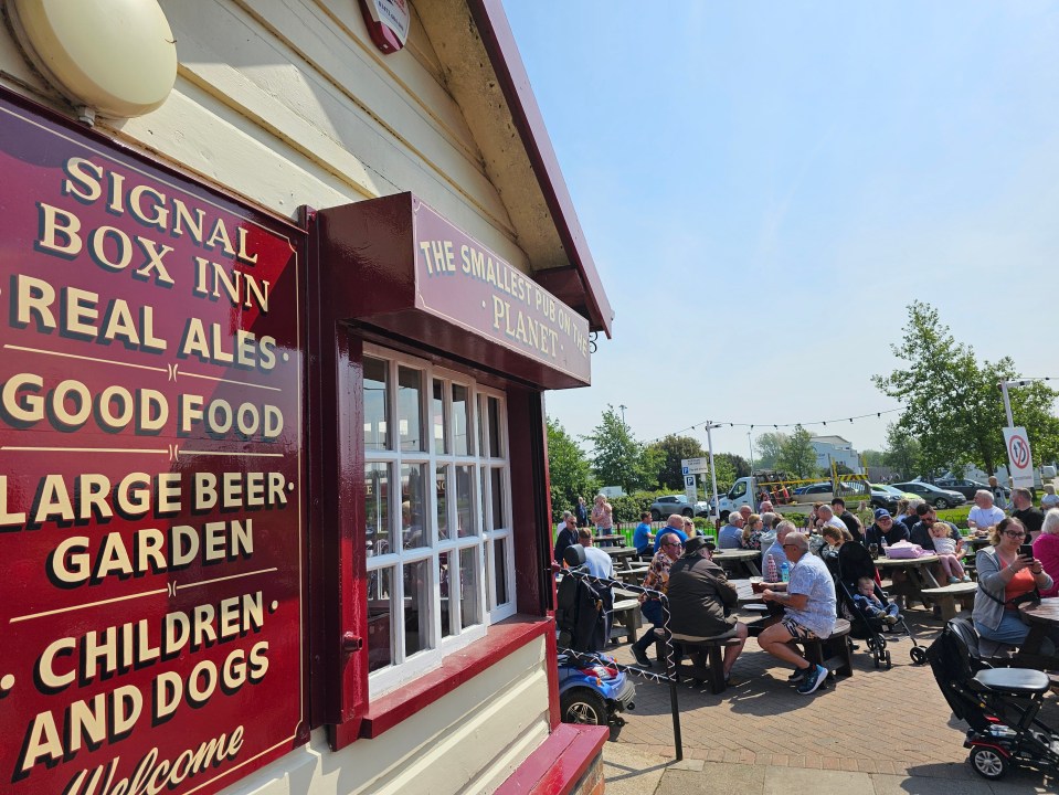 a large group of people are gathered outside the signal box inn