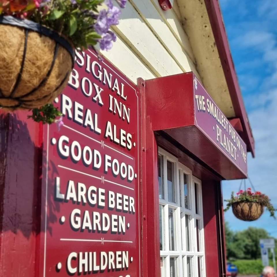 a red building with a sign that says signal box inn