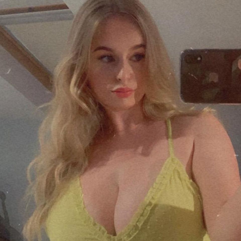 a woman in a yellow top is taking a selfie in front of a mirror .