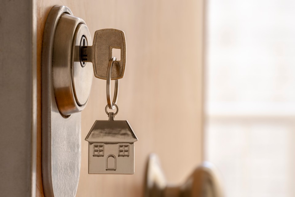 a key with a house keychain attached to it