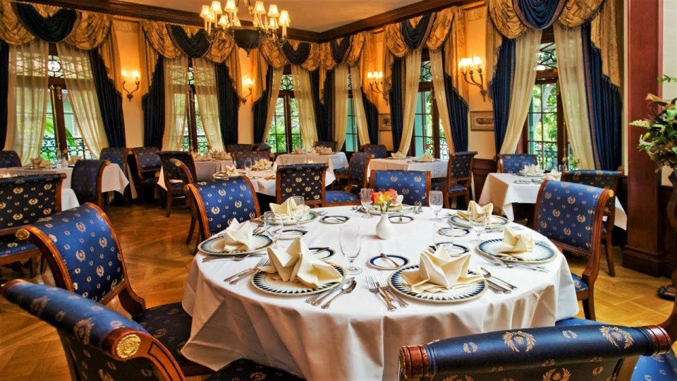 a dining room with blue and gold chairs and tables