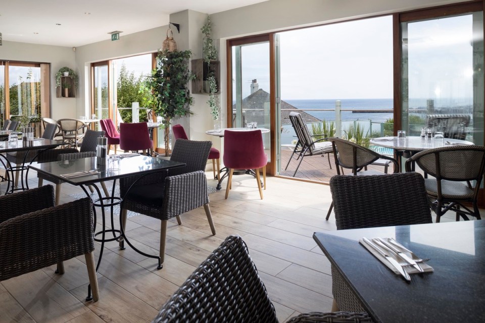 tables and chairs in a restaurant with a view of the ocean